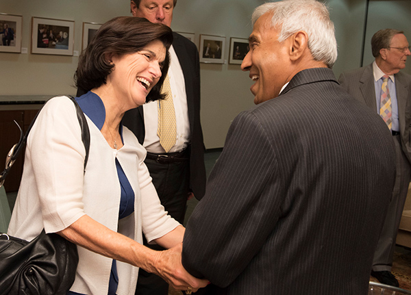 Woman and man shake hands while smiling